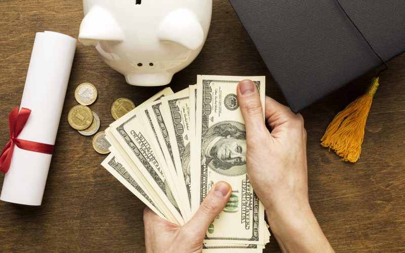 flat-lay-piggy-bank-with-academic-cap-banknotes